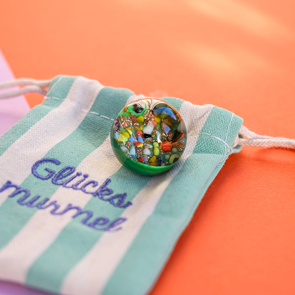 Kraftmurmel aus Muranoglas (Grün mit Konfetti-Steinchen) 25mm, in hochwertigem Stoffbeutel mit Stickerei