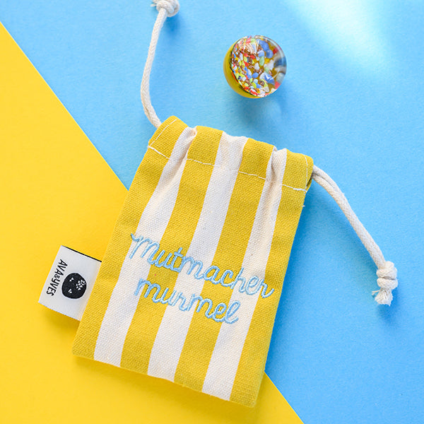 Kraftmurmel aus Muranoglas (gelb mit Konfetti-Steinchen) 25mm, in hochwertigem Stoffbeutel mit Stickerei